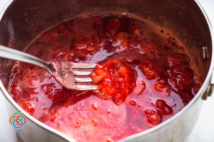 Strawberries and water simmering in a saucepan | Irish American Mom Strawberries simmering with water in a saucepan