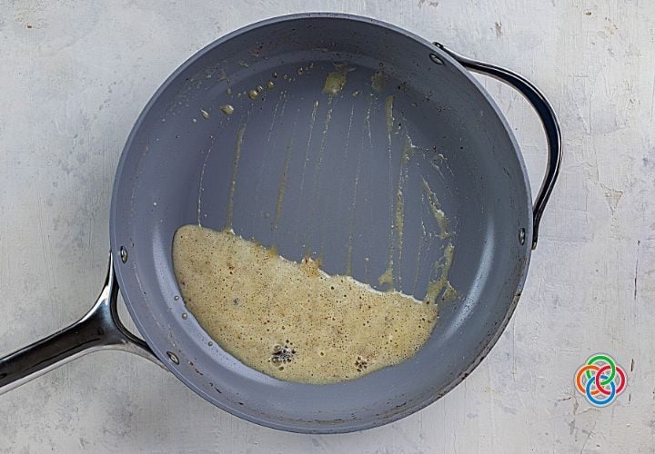 Making a whiskey cream sauce in a skillet for pork chops | Irish American Mom Making sauce in a skillet