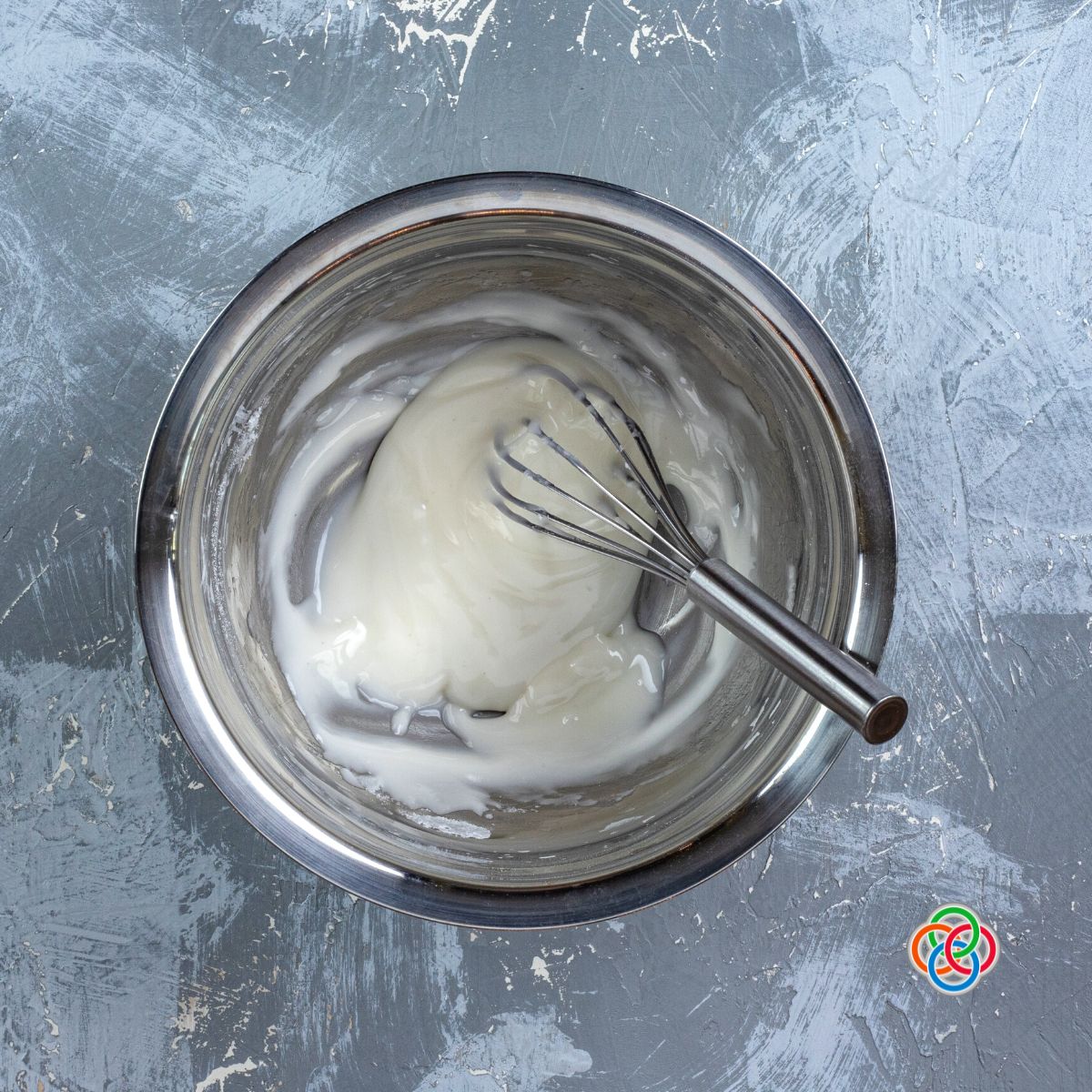 Lemon glaze for star cookies | Irish American Mom Mixing icing in a bowl with a balloon whisk