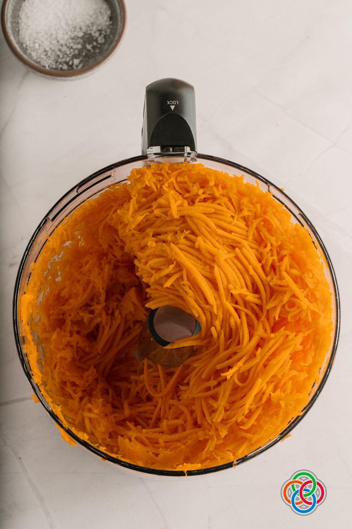Butternut squash and carrots in a food processor for homemade vegan vegetable stock cubes | Irish American Mom Shredded butternut squash in a food processor