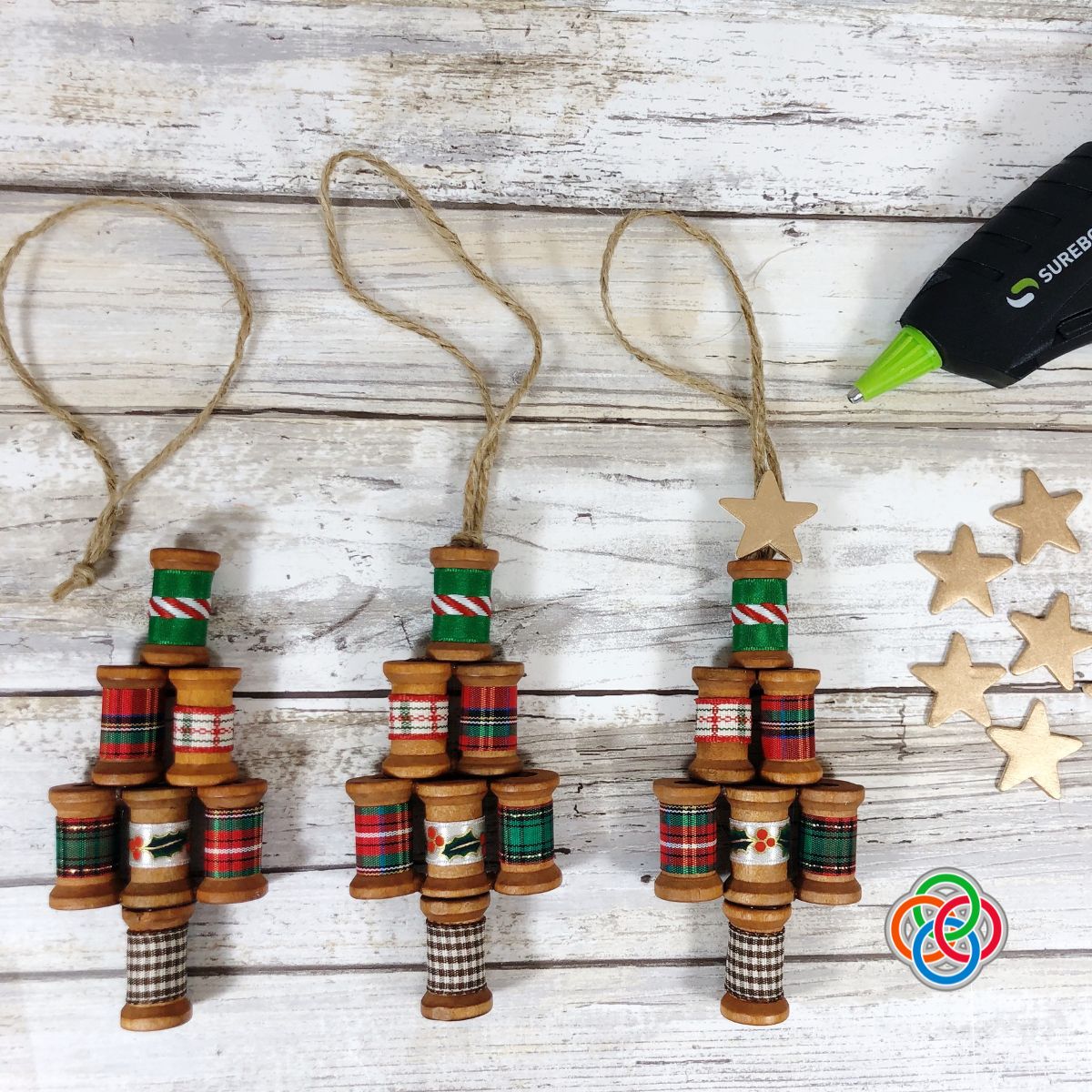 Adding a twine loop and star to a sewing spool Christmas tr | Irish American Mom Wooden spool Christmas trees with glue gun and stars
