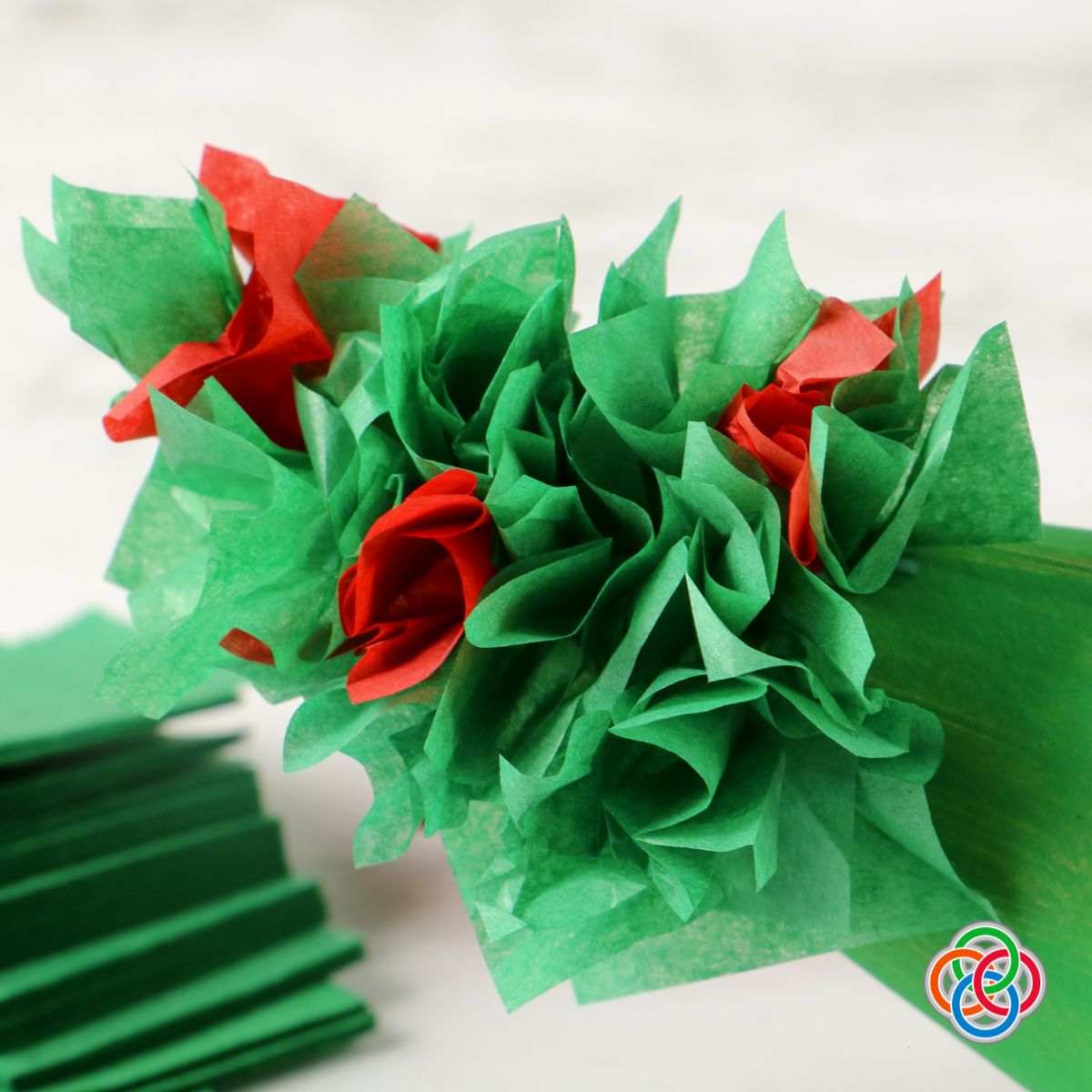 Gluing tissue paper clusters to a cardboard cone to make a decorative C | Irish American Mom Applying tissue paper clusters to a painted green cone