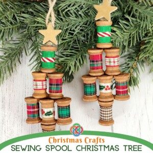 Two wooden spool Christmas tree ornaments with text banner