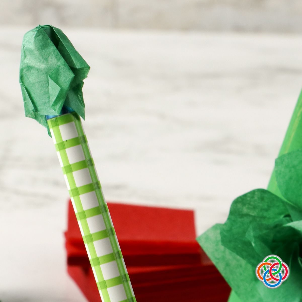 Using the end of a pencil to fold and crinkle tissue paper | Irish American Mom Tissue paper folded over the end of a pencil.