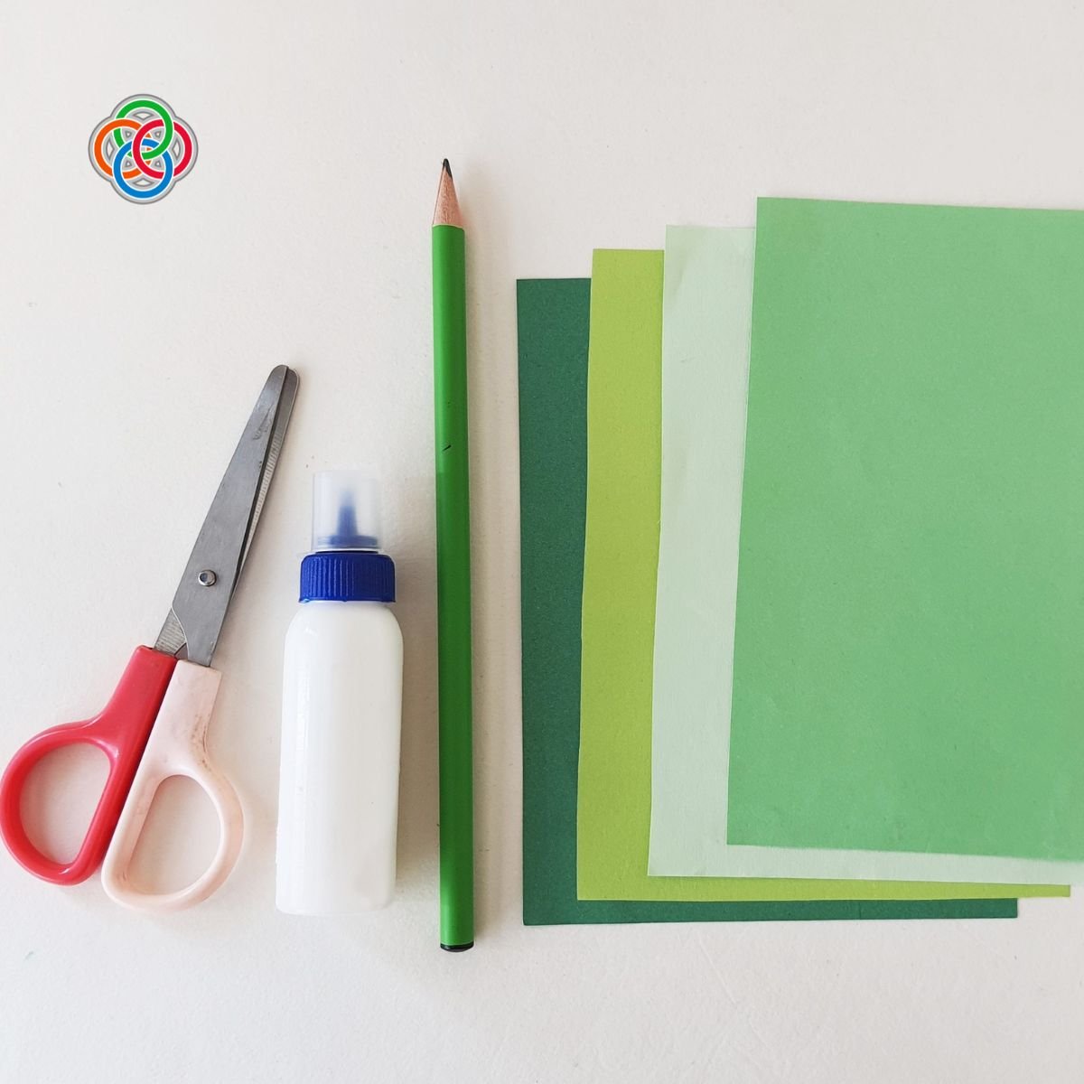 Materials for handprint shamrocks | Irish American Mom Sheets of paper pencil, glue and scissors