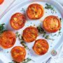 Roasted halved tomatoes on a platter with thyme