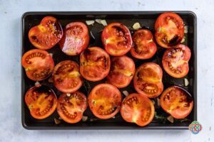 Tomatoes on a baking tray with balsamic vinegar drizzle