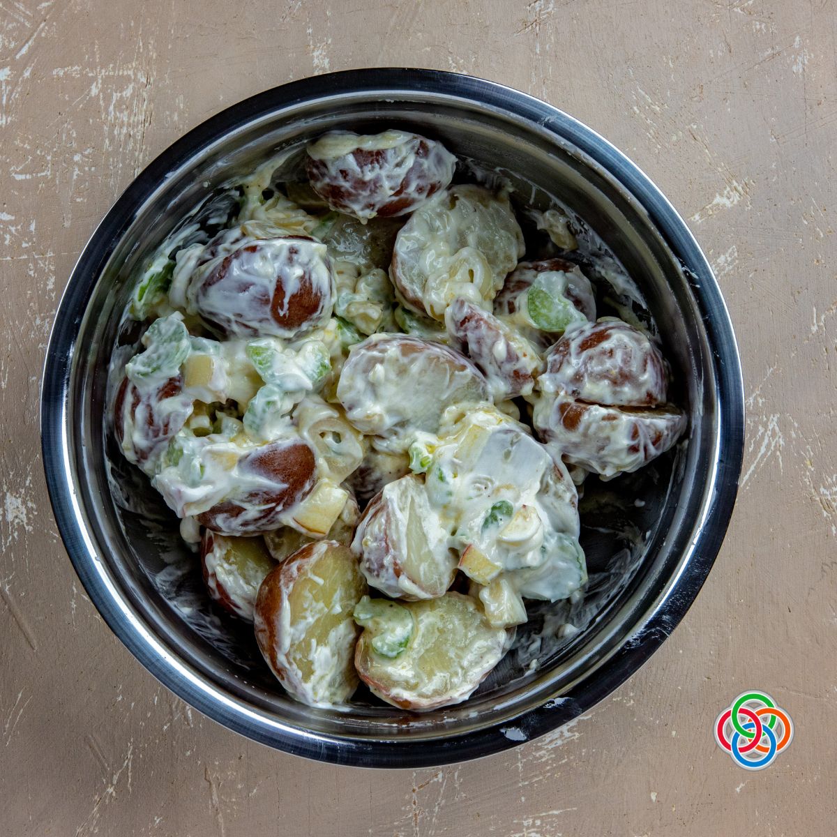 Tossing ingredients in mayonnaise and Greek yogurt for potato salad recipe | Irish American Mom Potato salad in a bowl