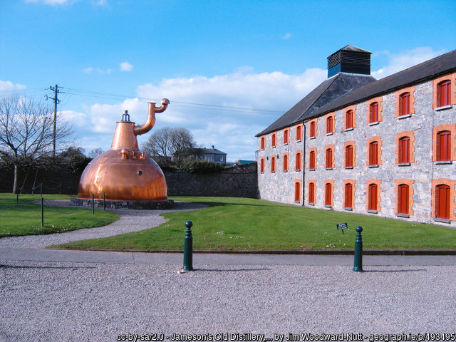 Copper whiskey still outiside and old building
