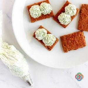 Broccoli cream cheese spread piped onto crackers