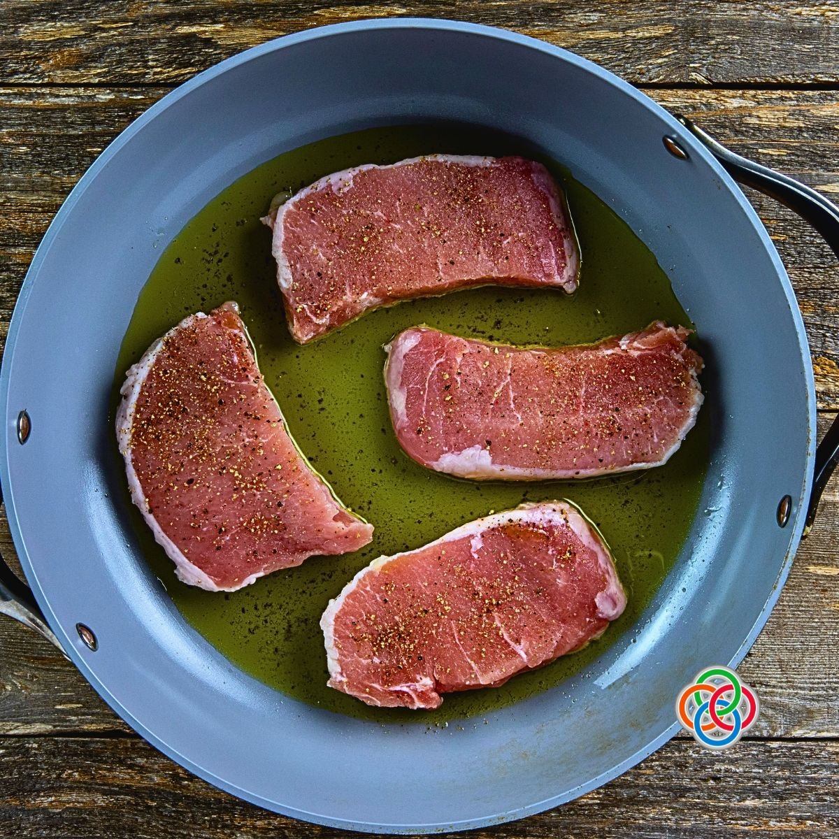Pork chops frying in a skillet | Irish American Mom pork chops cooking in oil in a skillet