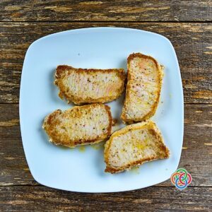 Four fried pork chops on a platter