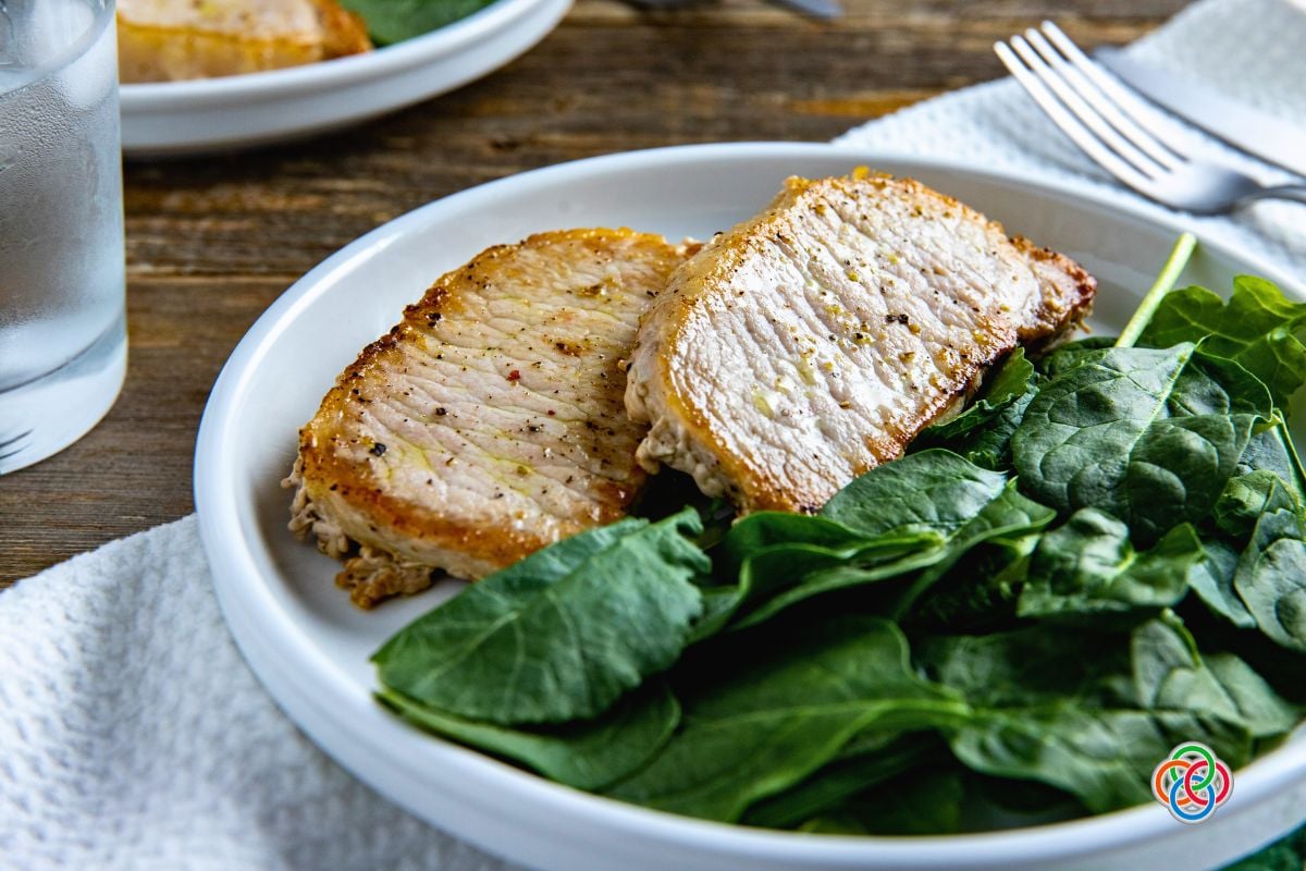 Skillet pork chops juicy and golden | Irish American Mom Cooked pork chops with spinach on a plate