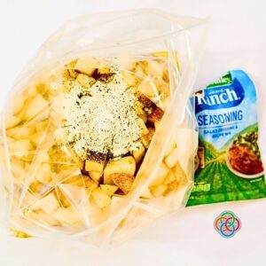 Chopped potatoes with ranch seasoning in a plastic bag