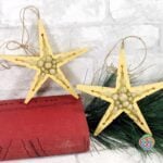 Wooden star ornaments displayed beside a book and pine branch