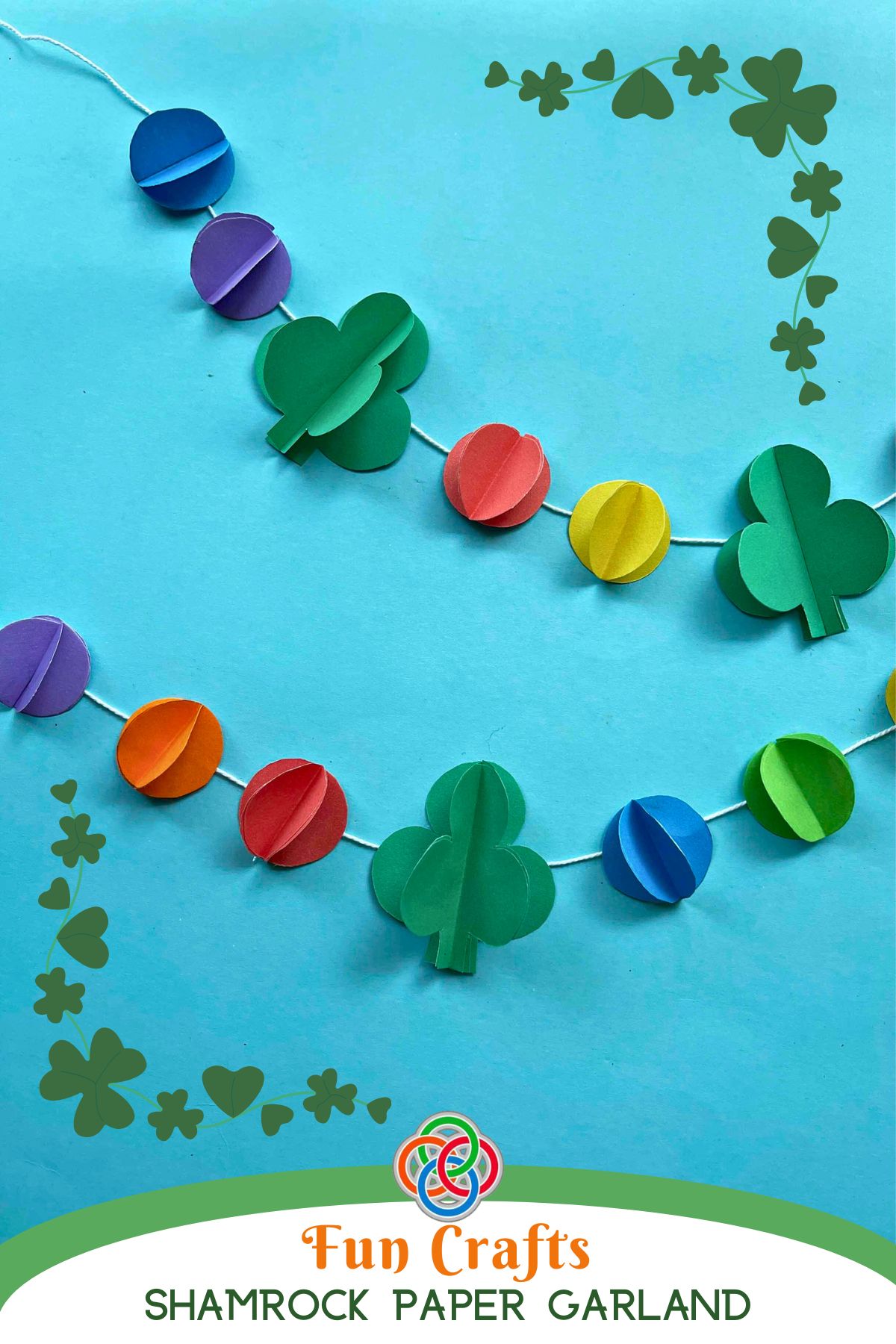 Colorful Saint Patrick's Day paper garland with 3D green shamrocks and rainbow paper balls hanging on white string against a blue background, with shamrock border and text reading 