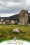 Ancient standing stones at Uragh Stone Circle in County Kerry, Ireland, set on grassy ground overlooking a lake with rugged mountains beneath a cloudy sky.