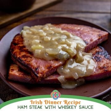 Ham steaks topped with creamy onion whiskey sauce on a brown plate, with text overlay reading “Irish Dinner Recipe Ham Steak with Whiskey Sauce.”