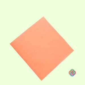 Select a back cover for your card for Pop Up Rainbow Card Craft | Irish American Mom Square piece of orange cardstock selected as the back cover for a Saint Patrick's Day pop up rainbow card craft.