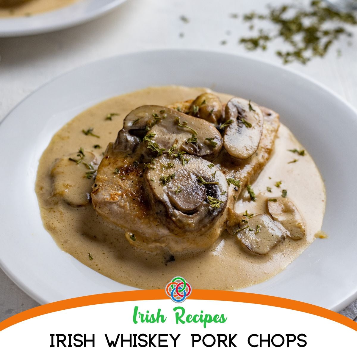 Pork chops in creamy mushroom whiskey sauce served in a skillet over text banner