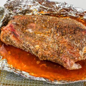 Cooked corned beef brisket resting in foil with juices after being cooked in an air fryer.