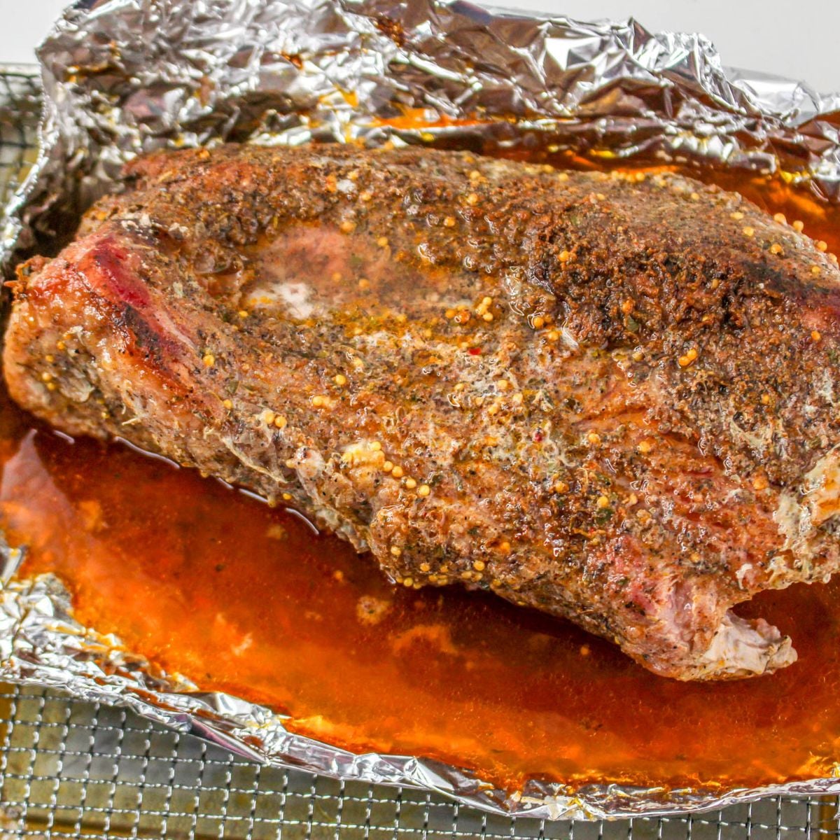 Cooked corned beef brisket resting in foil with juices after being cooked in an air fryer.