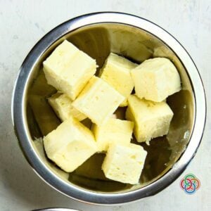 Overhead view of cubed feta cheese in a metal bowl prepared for Irish flag melon and cheese appetizer stacks.