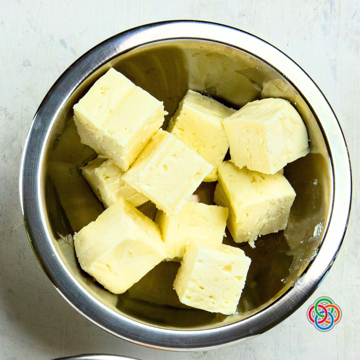 Overhead view of cubed feta cheese in a metal bowl prepared for Irish flag melon and cheese appetizer stacks.