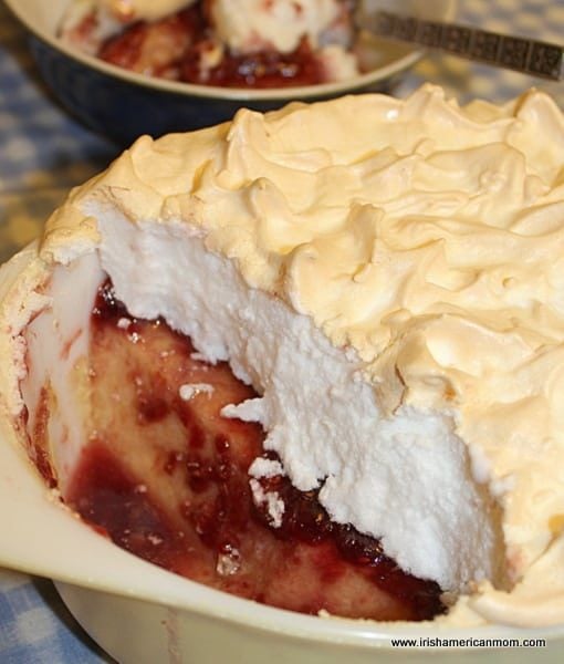 Queen of puddings dessert with custard base, jam layer, and golden meringue topping.