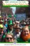 Crowd of people celebrating in a Saint Patrick’s Day parade wearing green and carrying Irish and American flags, representing the evolution of Saint Patrick’s Day celebrations in America.