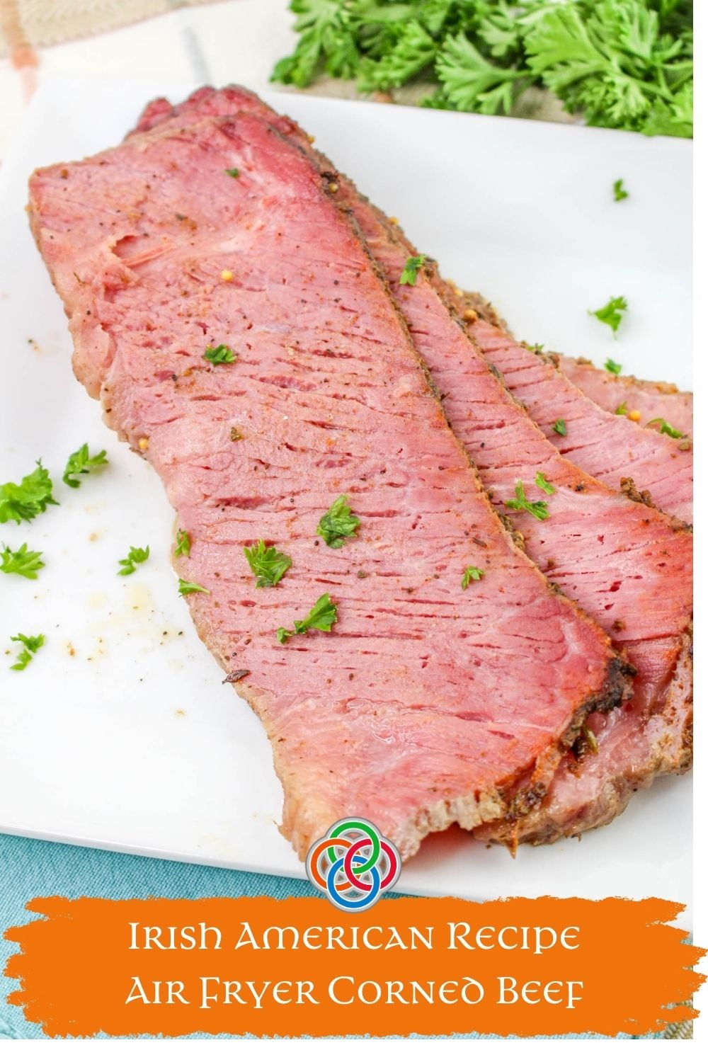 Close-up of sliced air fryer corned beef brisket with a seasoned crust and parsley garnish on a white plate, with text overlay reading “Irish American Cuisine Air Fryer Corned Beef Brisket.”