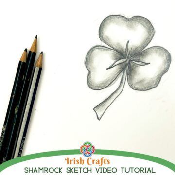 Shaded pencil drawing of a three-leaf shamrock with stem on white paper beside graphite pencils, with text reading “Irish Crafts Shamrock Sketch Video Tutorial” and a Celtic knot logo.