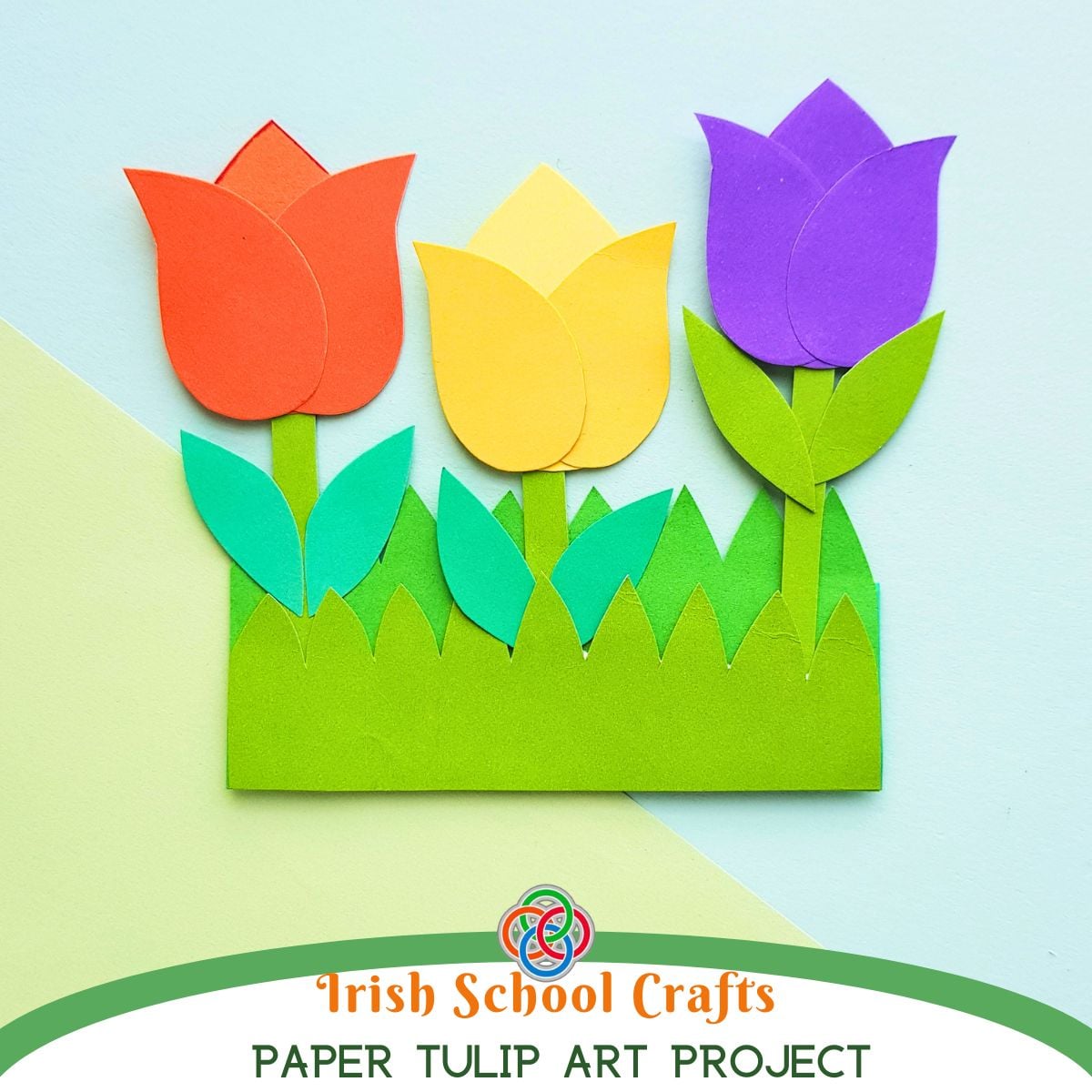 Colorful paper tulip craft with red, yellow, and purple flowers in a green grass pocket, labeled Irish School Crafts Paper Tulip Art Project.
