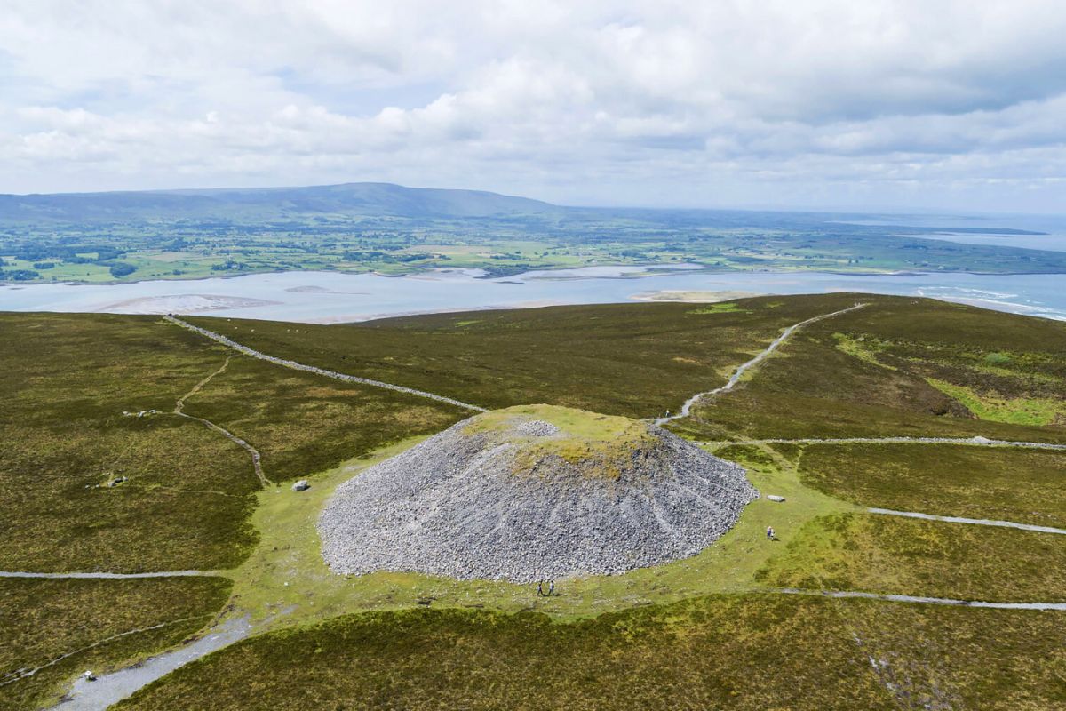 Queen Maeves Tomb on Knocknarea County Sligo | Irish American Mom Aerial view of Queen Maeve's Cairn on the summit of Knocknarea Mountain in County Sligo, Ireland, overlooking Sligo Bay and the green countryside below.