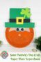 Finished St. Patrick’s Day paper plate leprechaun craft with glittery orange beard, googly eyes, green hat with yellow buckle, and shamrock decoration.