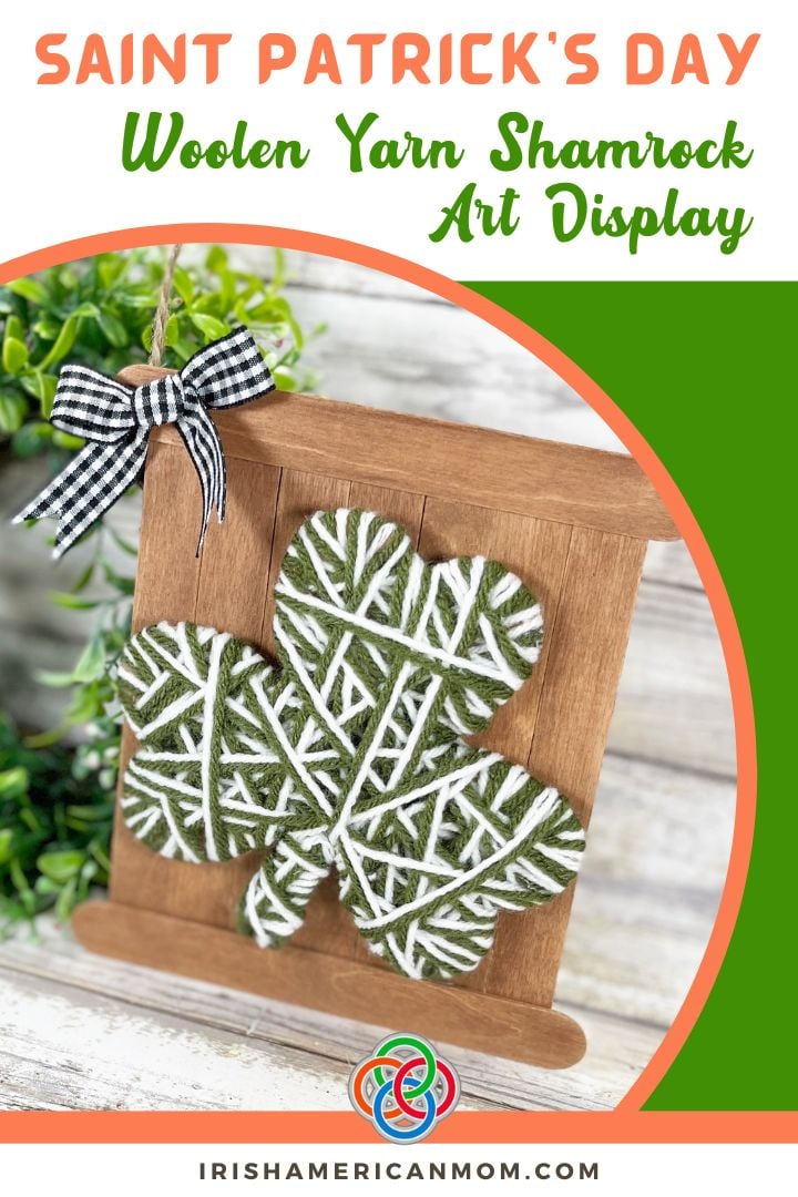 Woolen yarn wrapped shamrock mounted on a rustic craft stick sign with a gingham bow for a St. Patrick’s Day art display decoration.