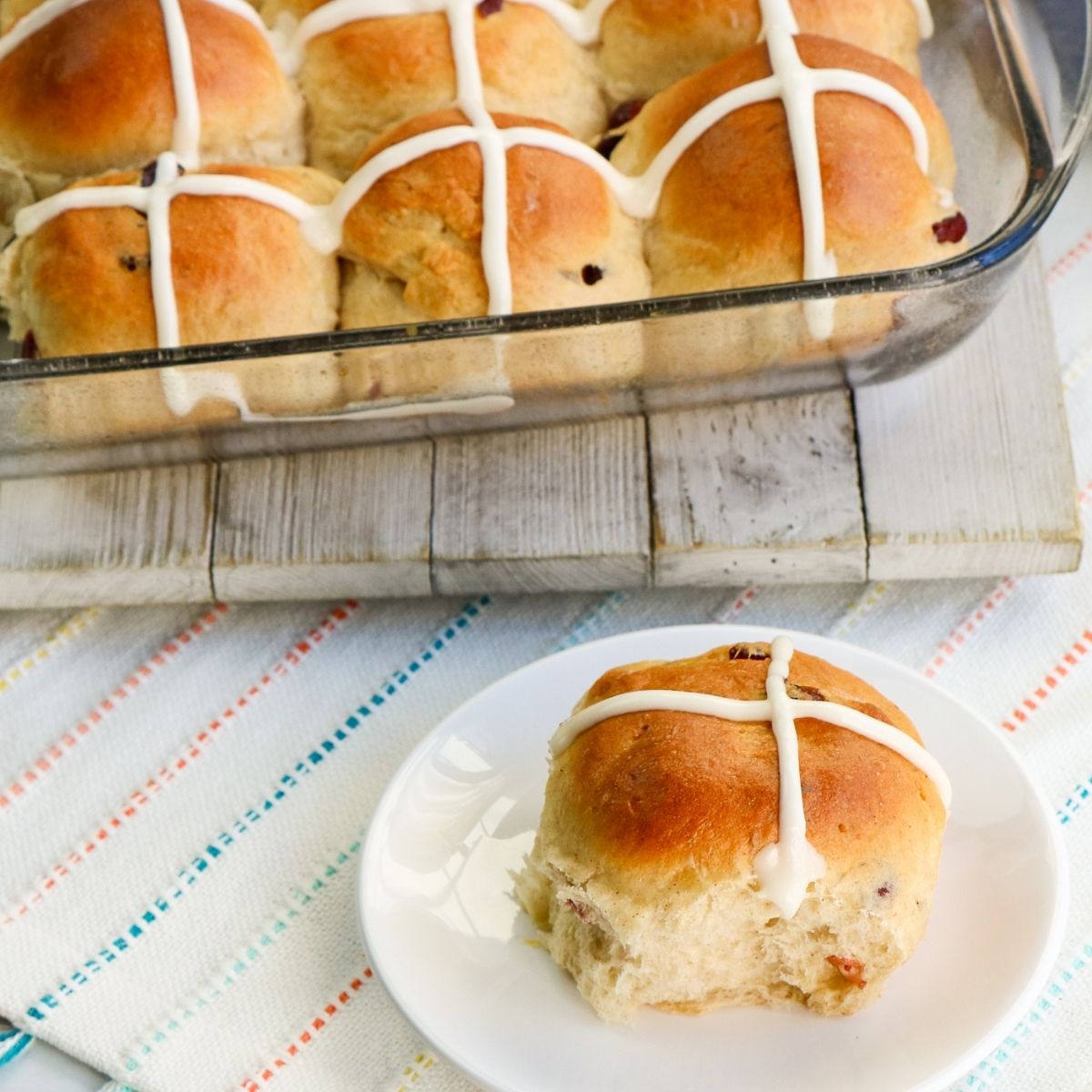Hot cross buns made in a bread machine served on a plate.
