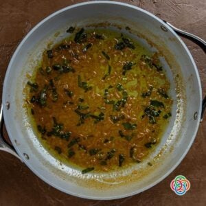 Adding sage to beer and shallots in a skillet for a pork gravy | Irish American Mom Fresh sage added to a skillet of shallots and beer, creating a rich Irish-style gravy for pork.