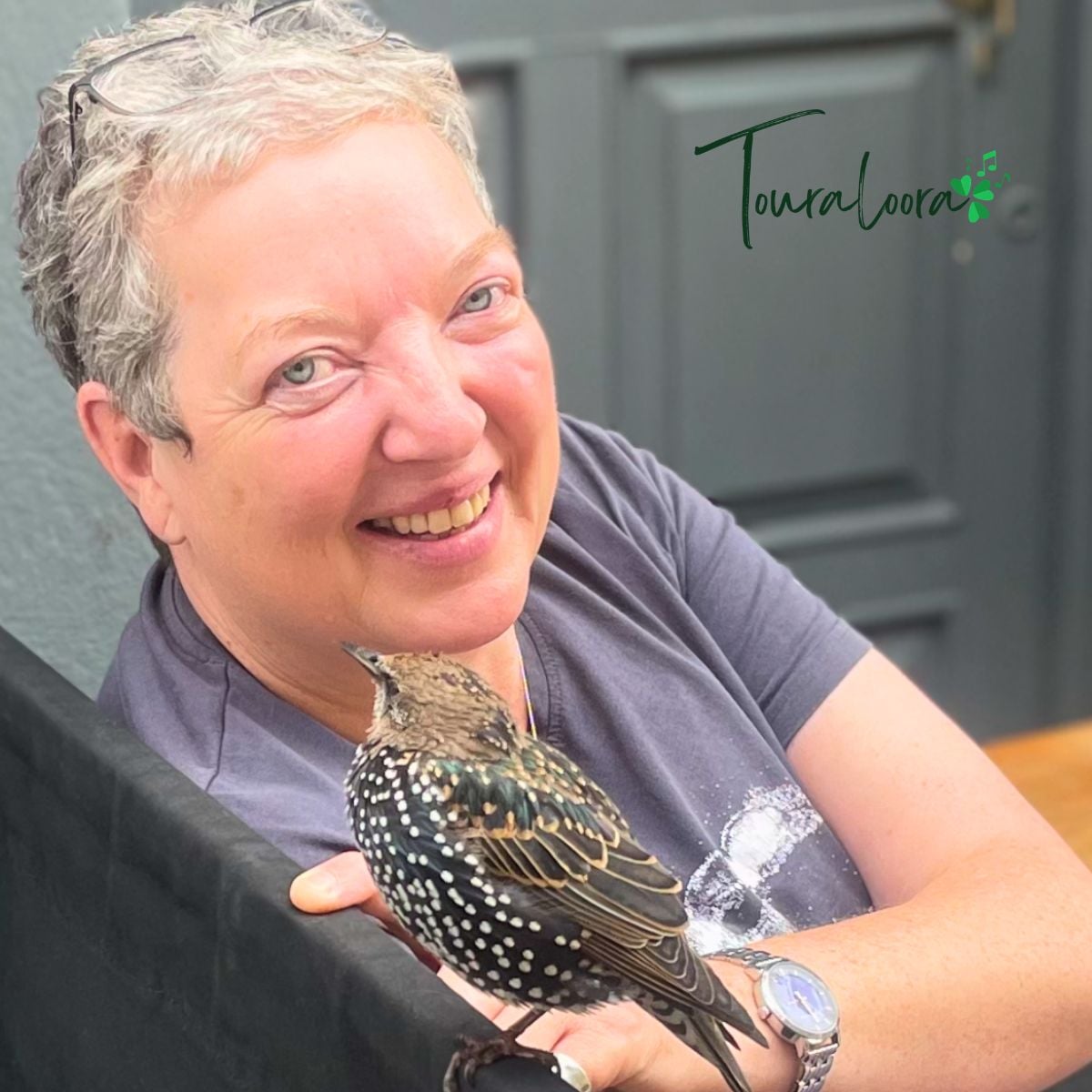 Headshot of a woman with a bird on her hand plus Touraloora branding