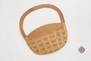 Paper Easter basket base made from brown cardstock with a woven strip design and attached handle, displayed on a plain background.