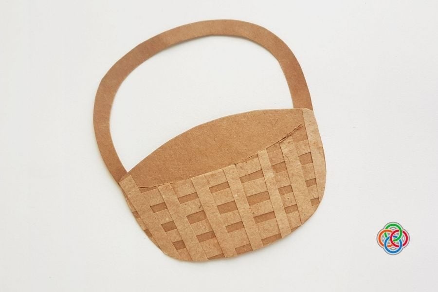 Paper Easter basket base made from brown cardstock with a woven strip design and attached handle, displayed on a plain background.