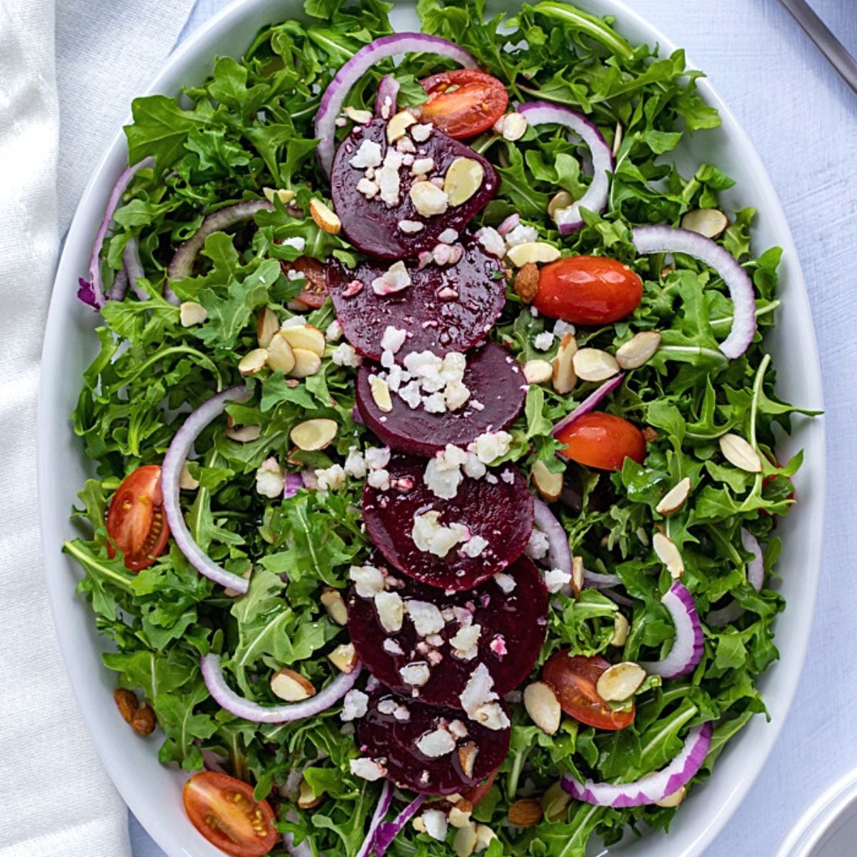 Salad with beetroot, goat cheese, arugula, and tomatoes.