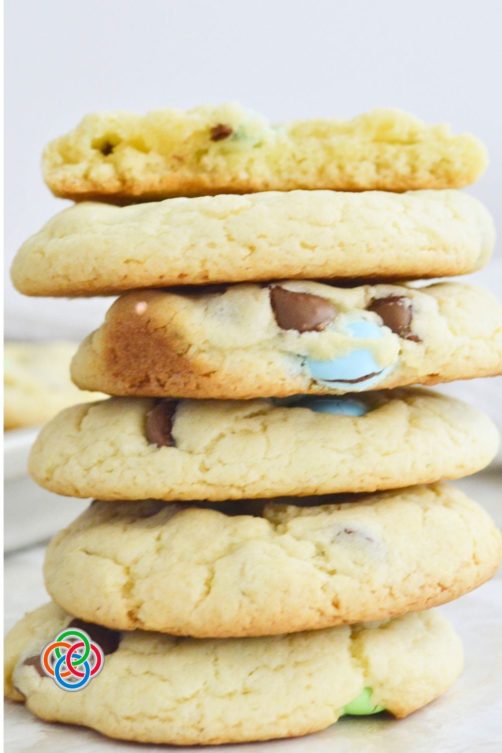 Close-up stack of soft cake mix cookies with pastel coloured candies and chocolate chips, showing their thick, chewy texture.