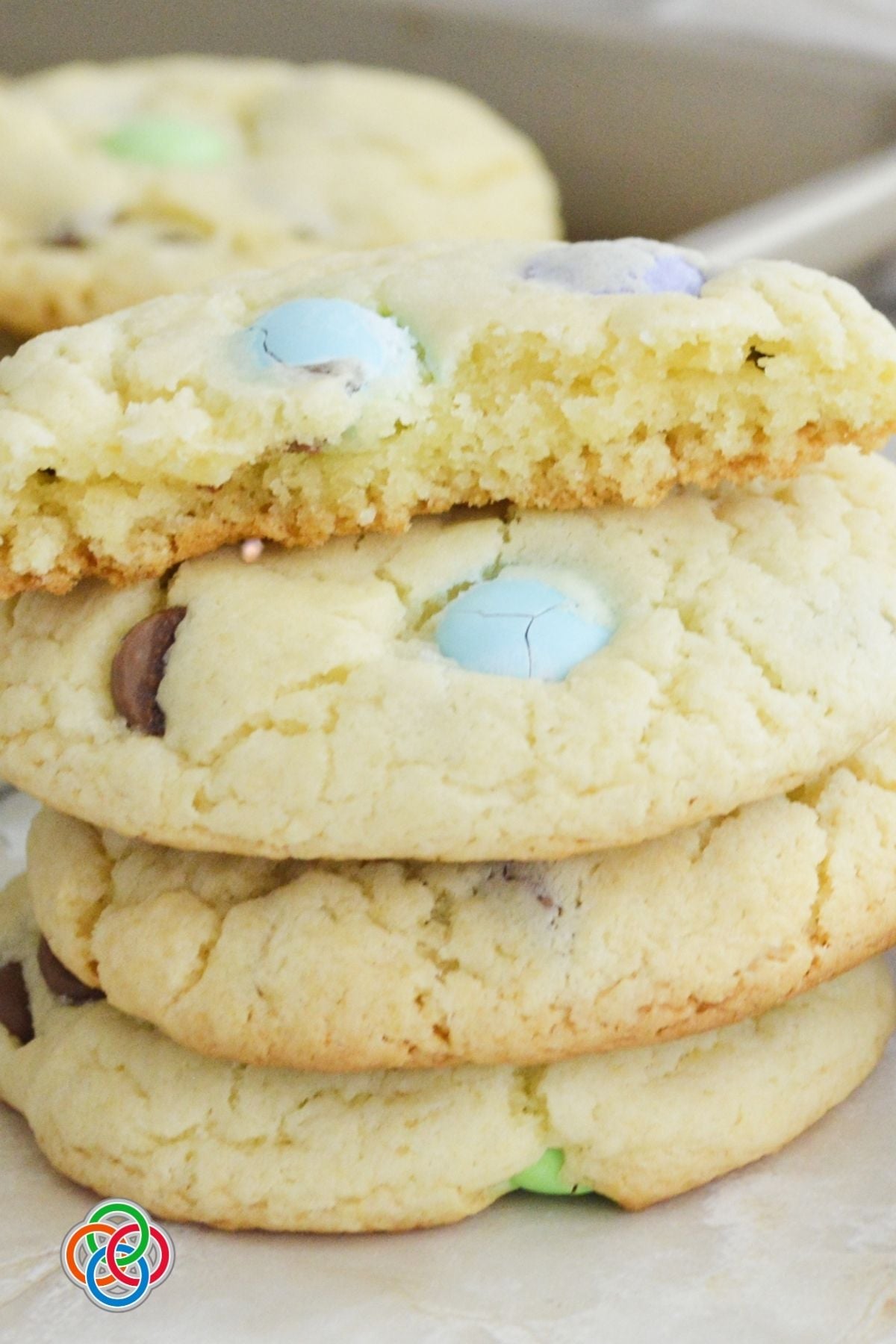 Close-up of soft cake mix cookies with pastel M&M candies and chocolate chips, showing their tender texture and golden edges.