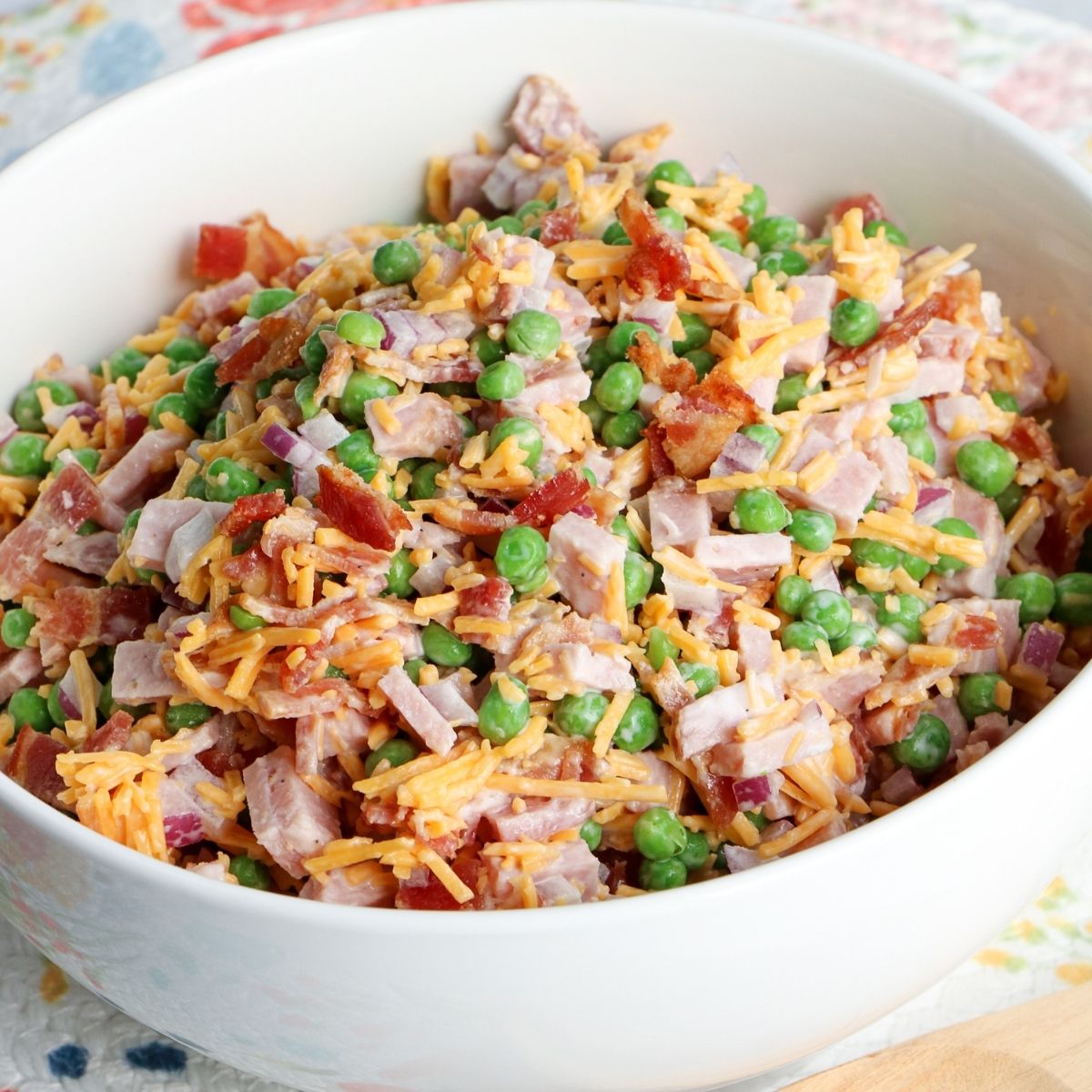 Creamy ham and pea salad served in a white bowl.