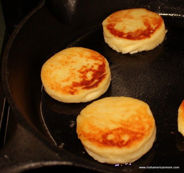 Golden fried Irish potato cakes in a cast iron pan.