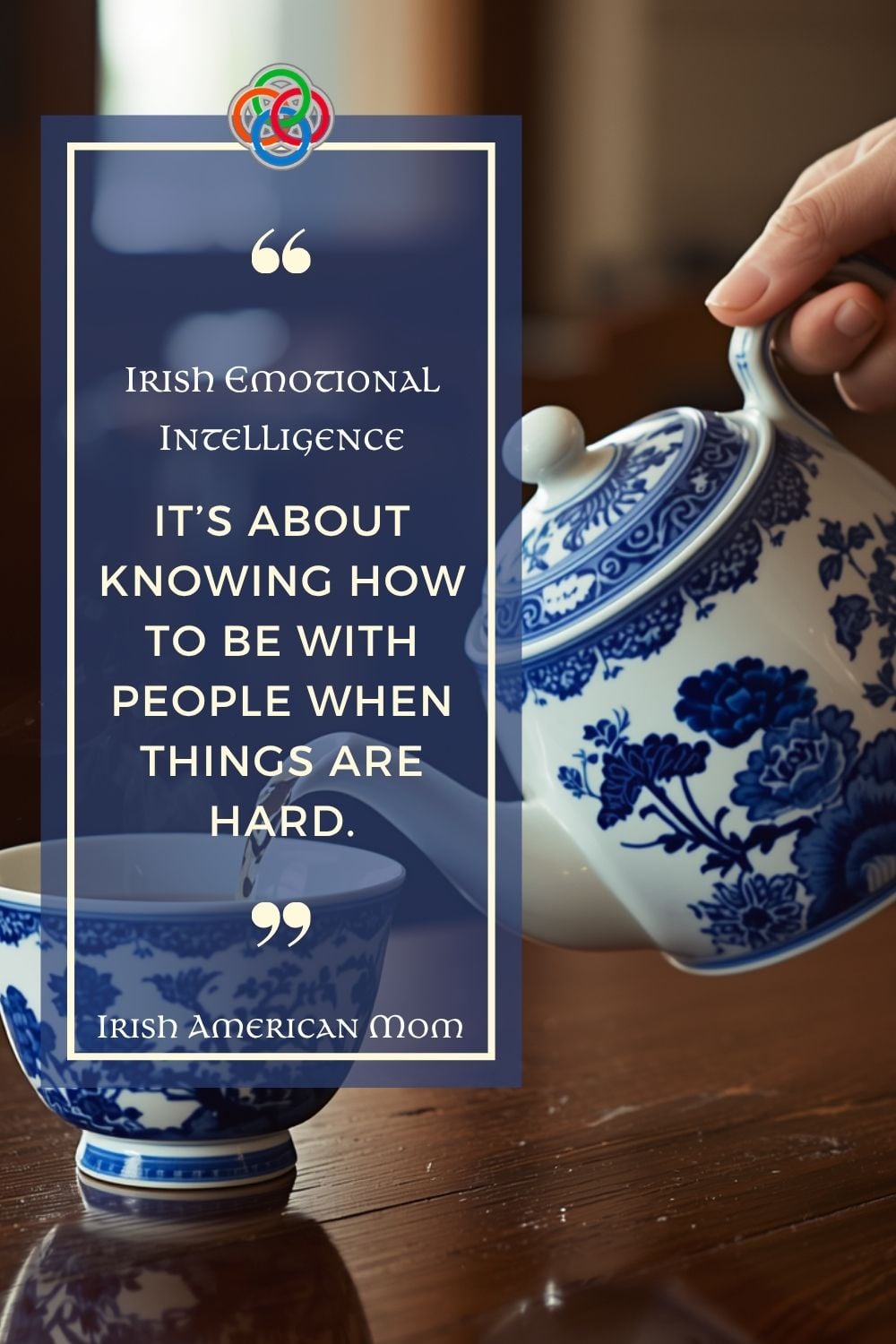 A Pinterest-style quote graphic featuring a blue and white teapot pouring tea into a cup beside a navy text panel. The quote reads, “Irish Emotional Intelligence – It’s about knowing how to be with people when things are hard.” The design includes soft cream text, decorative quotation marks, and Irish American Mom branding.