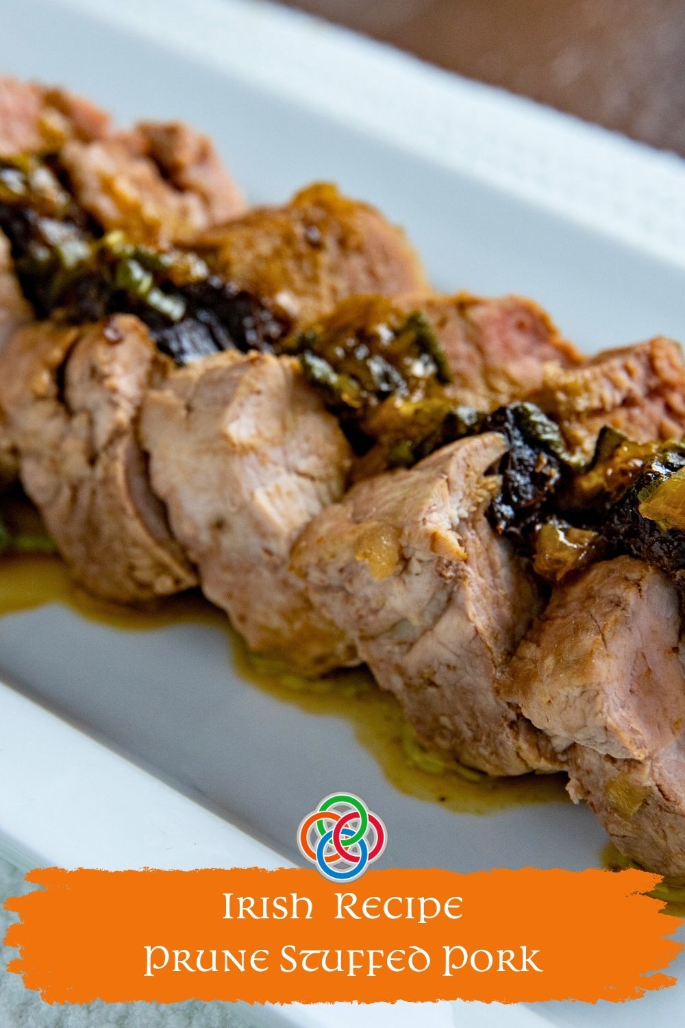 Close-up of sliced pork tenderloin stuffed with prunes and topped with a rich gravy, labeled Irish prune stuffed pork recipe.