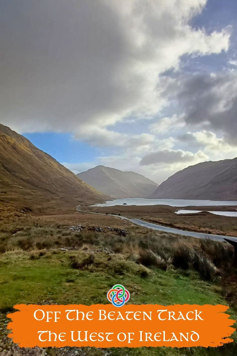 Scenic mountain valley with a winding road and lake in the west of Ireland with text overlay “Off the Beaten Track The West of Ireland.”