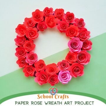 A handmade circular wreath decorated with layered red and pink paper roses, displayed on a soft green and white background with “Paper Designs Rose Wreath School Craft” text below.